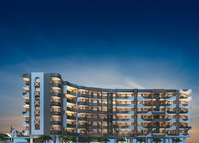 A curved-facade apartment building at night, lit floor by floor.